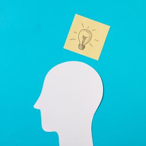 Drawn Light Bulb Icon Sticky Note Paper Cut Out Head Against Blue Background